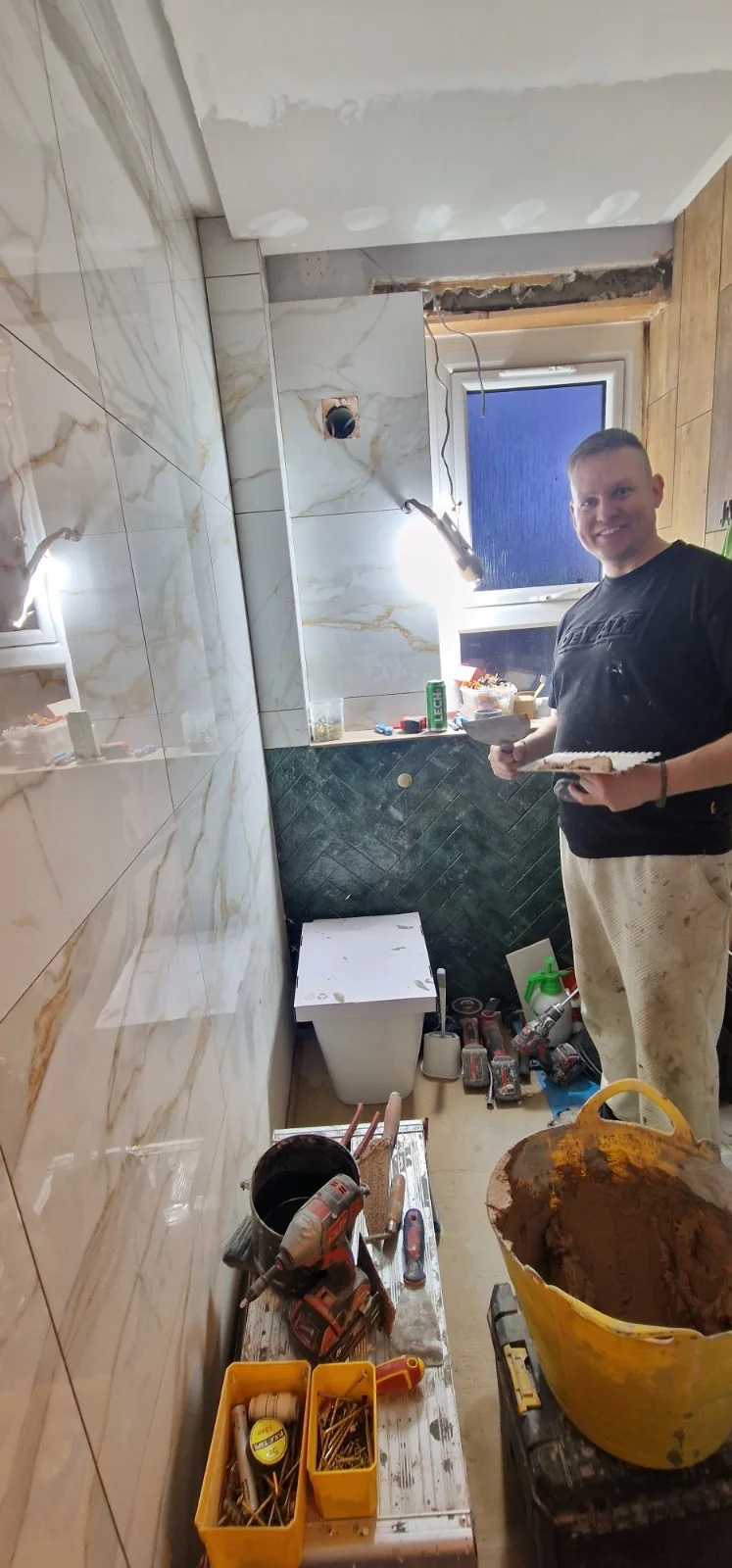 Gold-vein marble-effect wall tiles being set during a renovation