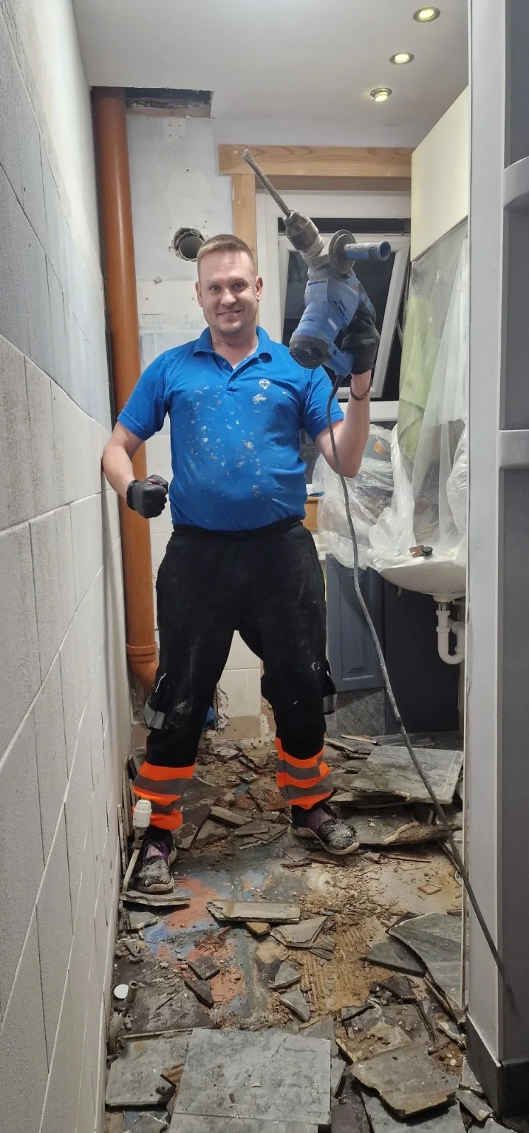 Old bathroom floor tiles being broken out during strip-out