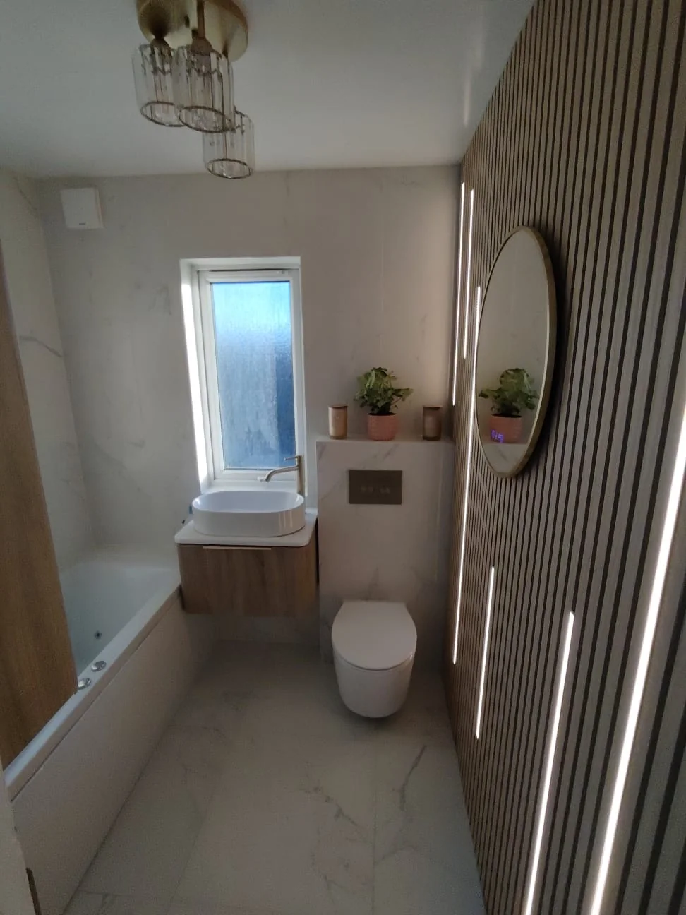 Marble-effect bathroom with timber slat feature wall and LED strip lighting