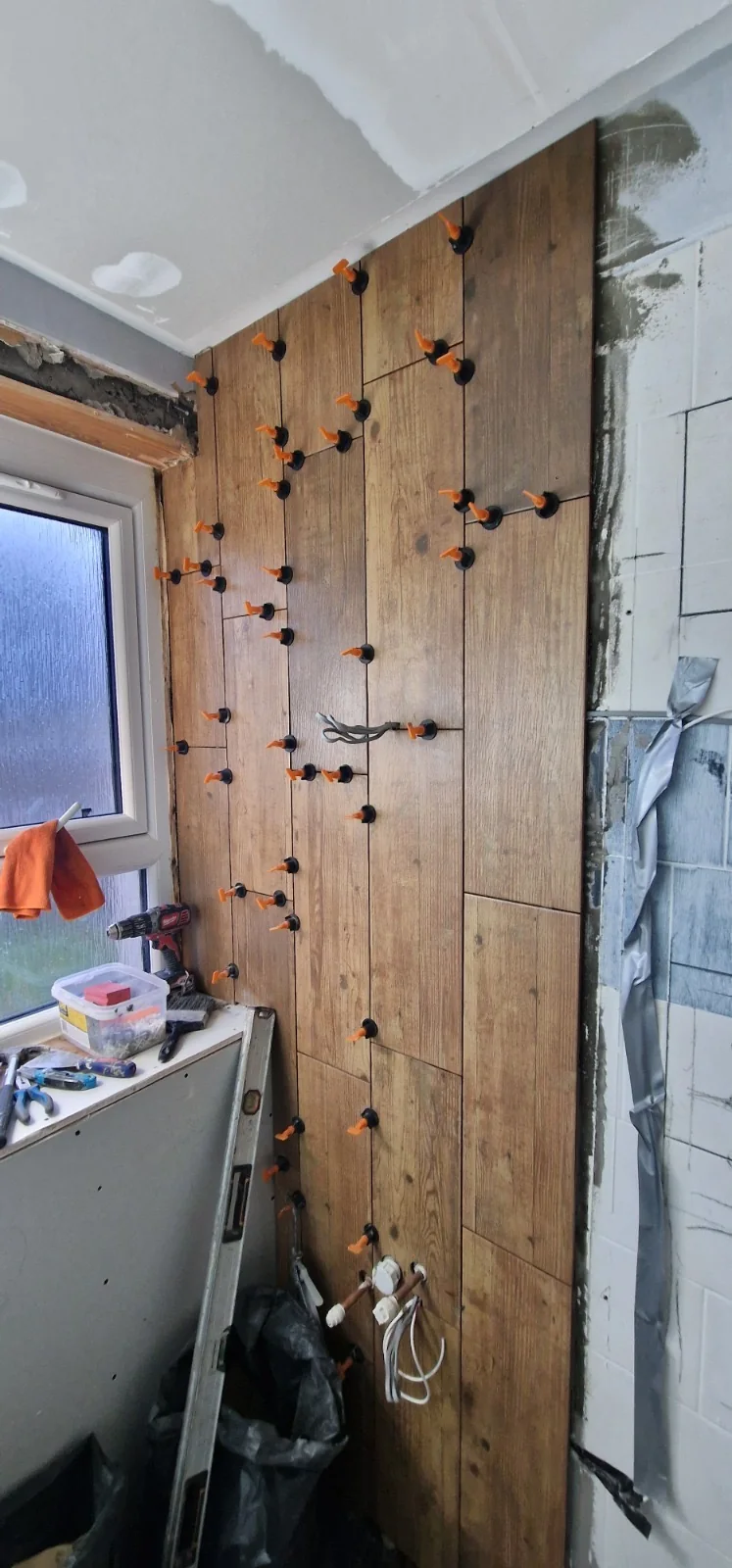 Wood-effect wall tiles set with a levelling system